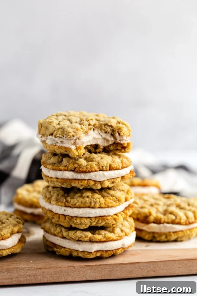 Festive Plant-Based Cookie Delights 11 Stack of vegan oatmeal cream pies on a wood and marble serving board, with a bite taken from the top cookie