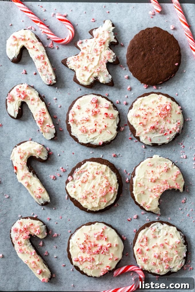 Festive Plant-Based Cookie Delights 3 Sheet pan filled with dark chocolate cut-out cookies topped with vanilla frosting and crushed peppermint candies