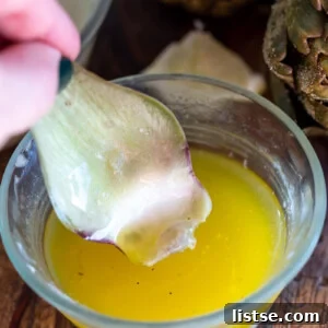 Sensational Artichoke Dips 9 piece of artichoke being dipping in lemon butter