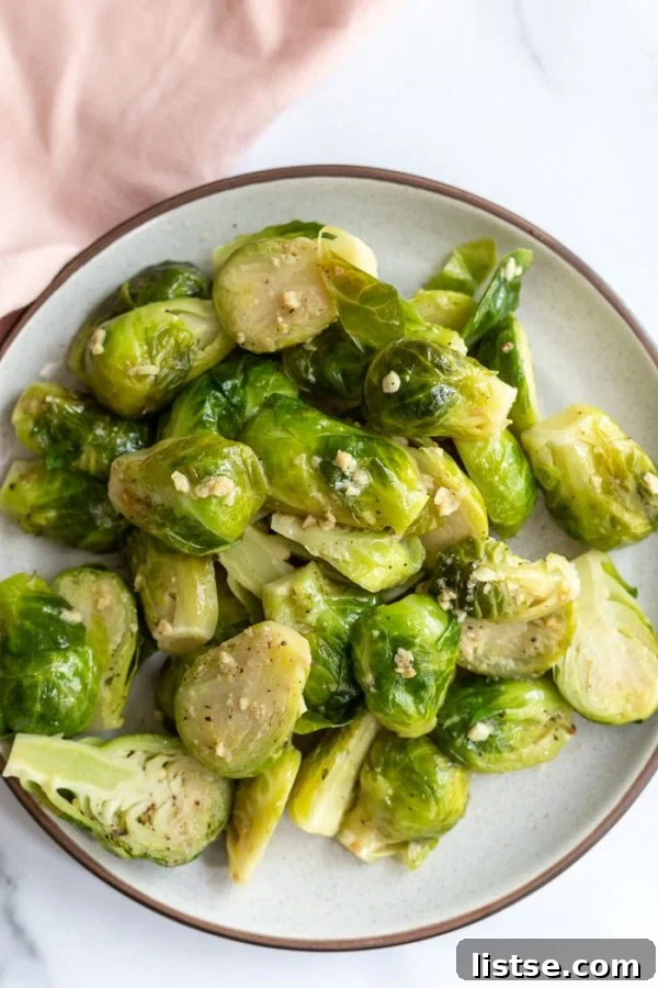 Instant Pot Brussels Sprouts on a white plate, garnished with fresh herbs.