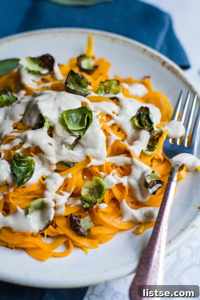 Butternut squash noodles with crispy Brussels sprouts and a creamy sauce.