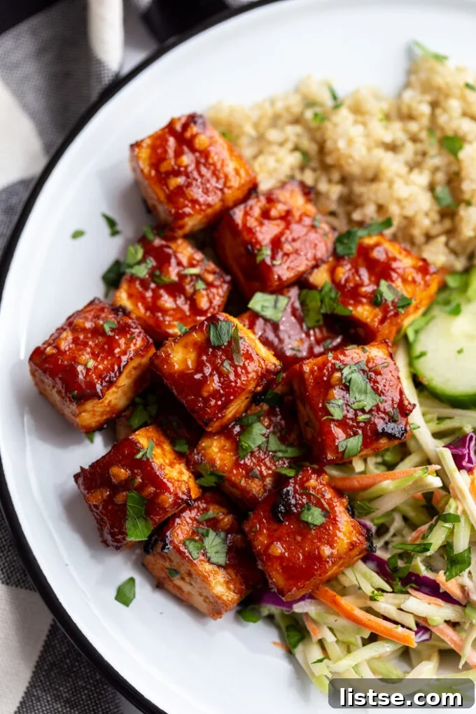 large white dish with quinoa and coleslaw in the corner with the highlight being large cubes of bbq tofu
