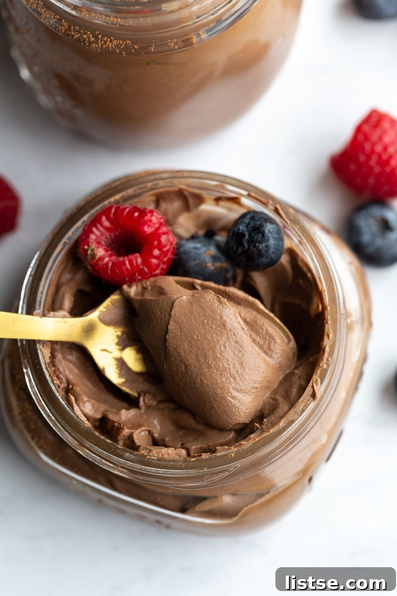 Dreamy Vegan Silken Tofu Chocolate Mousse 7 spooning out a bite of vegan chocolate mousse from a small glass jar