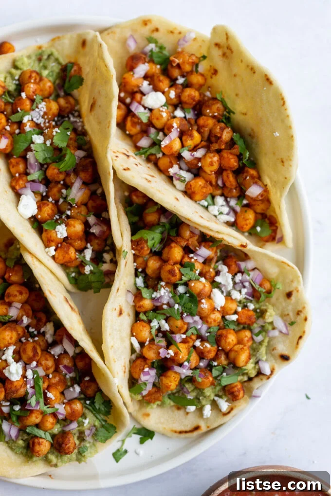Spiced Chickpea Tacos 4 Chickpea tacos with fresh cilantro and crumbled feta cheese on a white serving tray