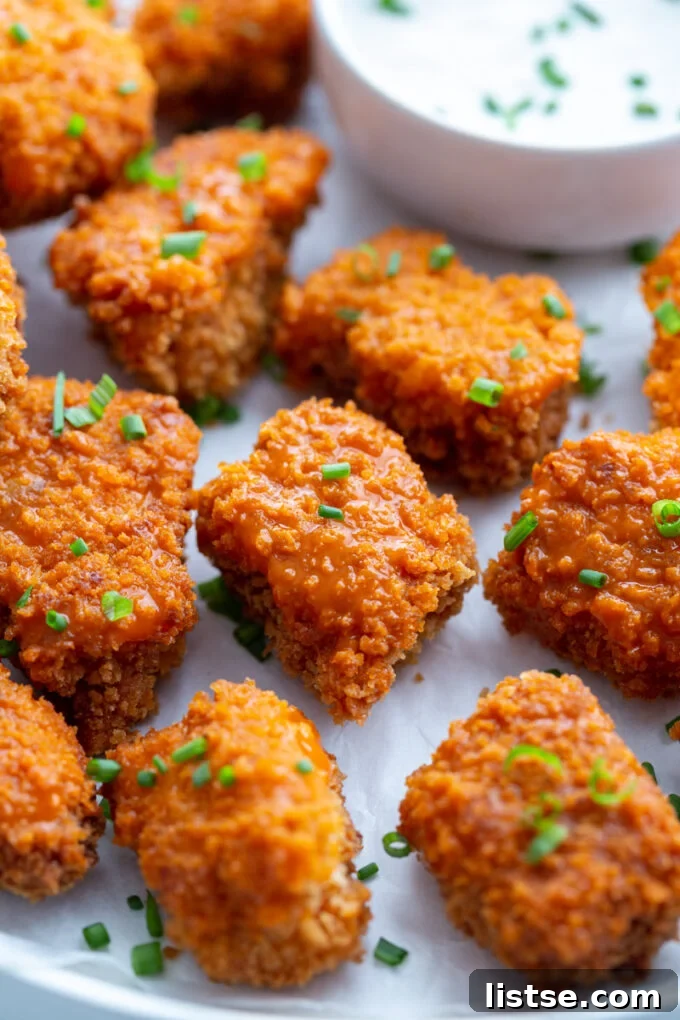 Crispy Buffalo Tempeh Bites 4 Crispy chunks of buffalo tempeh arranged artistically, showcasing the golden-brown breading and spicy glaze.