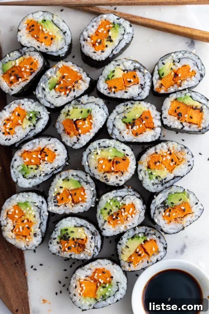 Delicious sweet potato sushi rolls artfully arranged on a plate with a side of soy sauce, ready to be enjoyed.