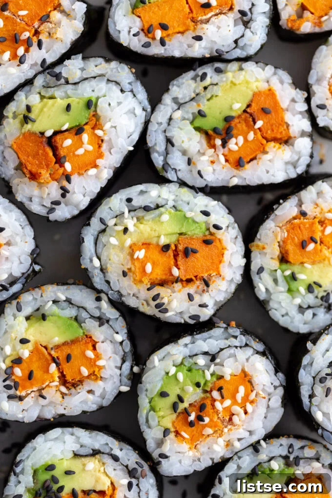 Two pieces of Sweet Potato Roll Sushi, sliced and presented neatly, revealing the vibrant sweet potato and avocado filling.