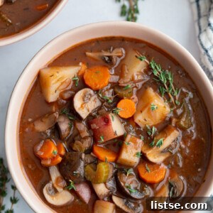 Vegan stew served in a small white bowl with fresh thyme