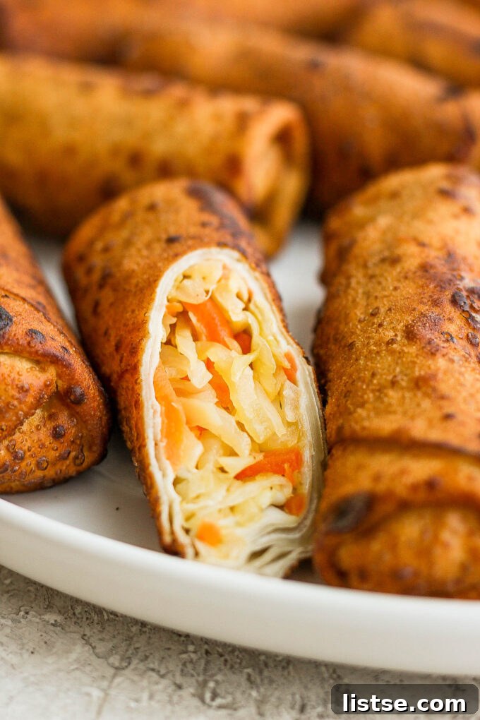 A serving platter showcasing golden-brown vegan egg rolls, perfectly arranged and ready to be enjoyed.
