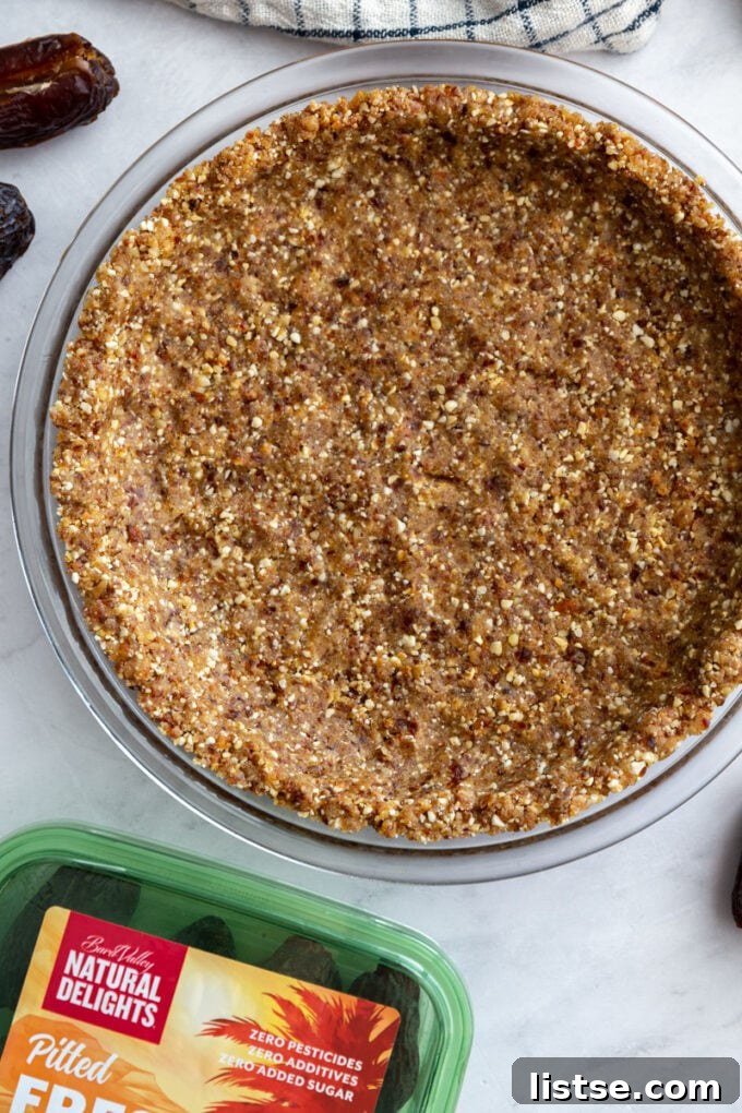 medjool date no bake pie crust with a box of medjool dates on the side