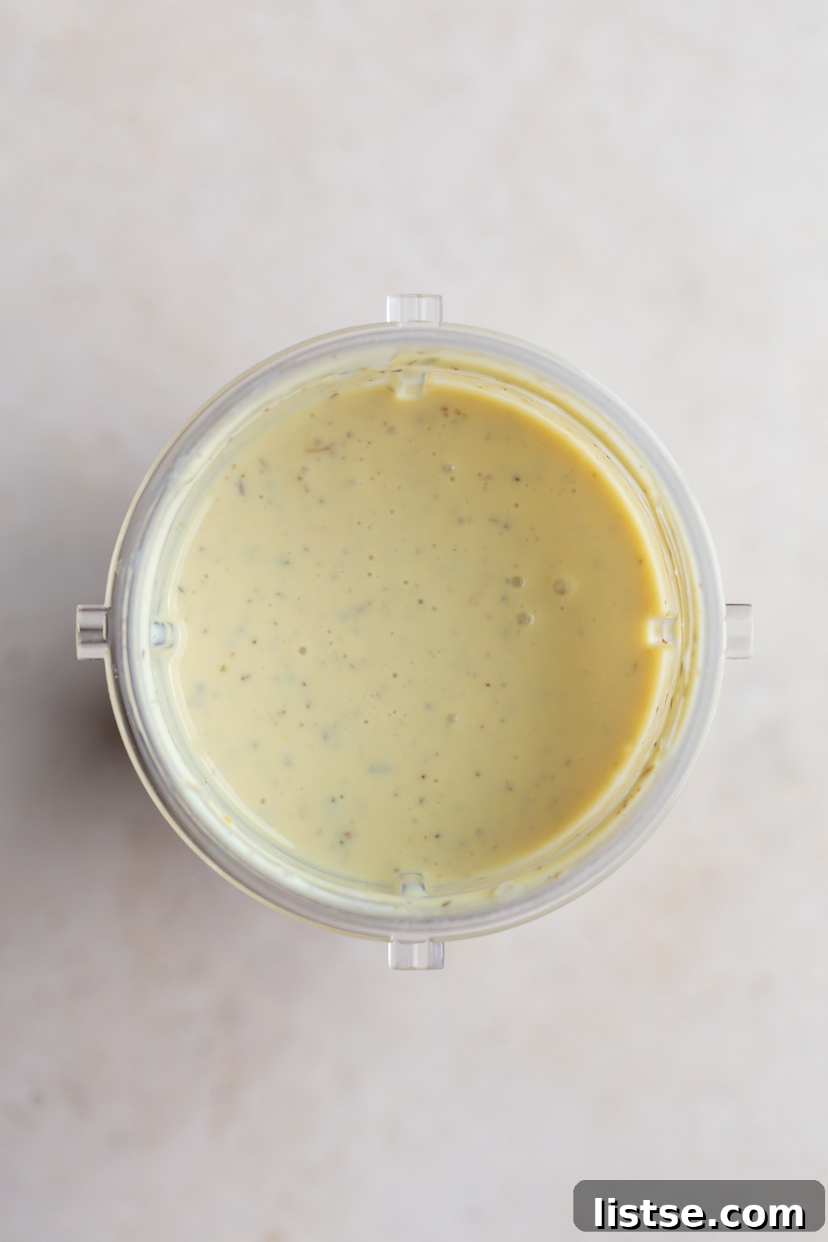 Velvety Vegan Alfredo 6 All the sauce ingredients blended into a smooth, creamy mixture in a blender cup.
