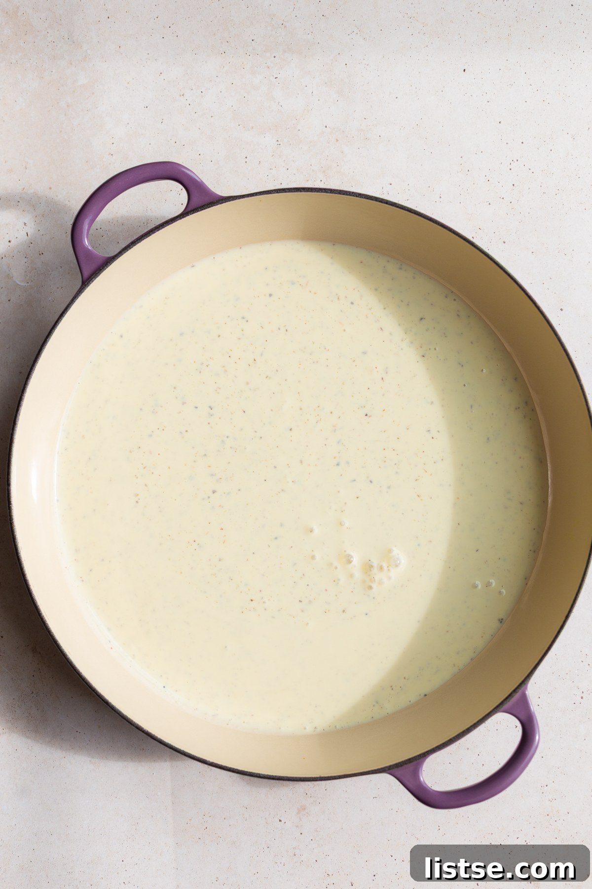 Velvety Vegan Alfredo 7 The blended creamy tofu pasta sauce being gently heated in a medium-sized saucepan on the stove.