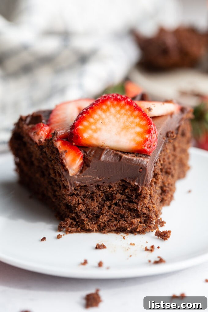 Decadent Plant-Based Chocolate Ganache 4 A perfectly portioned slice of rich chocolate cake adorned with glistening vegan chocolate ganache, highlighting its smooth texture.