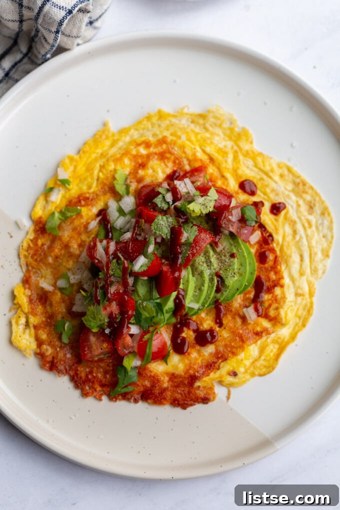 Close-up of a golden-brown breakfast taco filled with eggs, cheese, and fresh toppings, ready to be enjoyed.