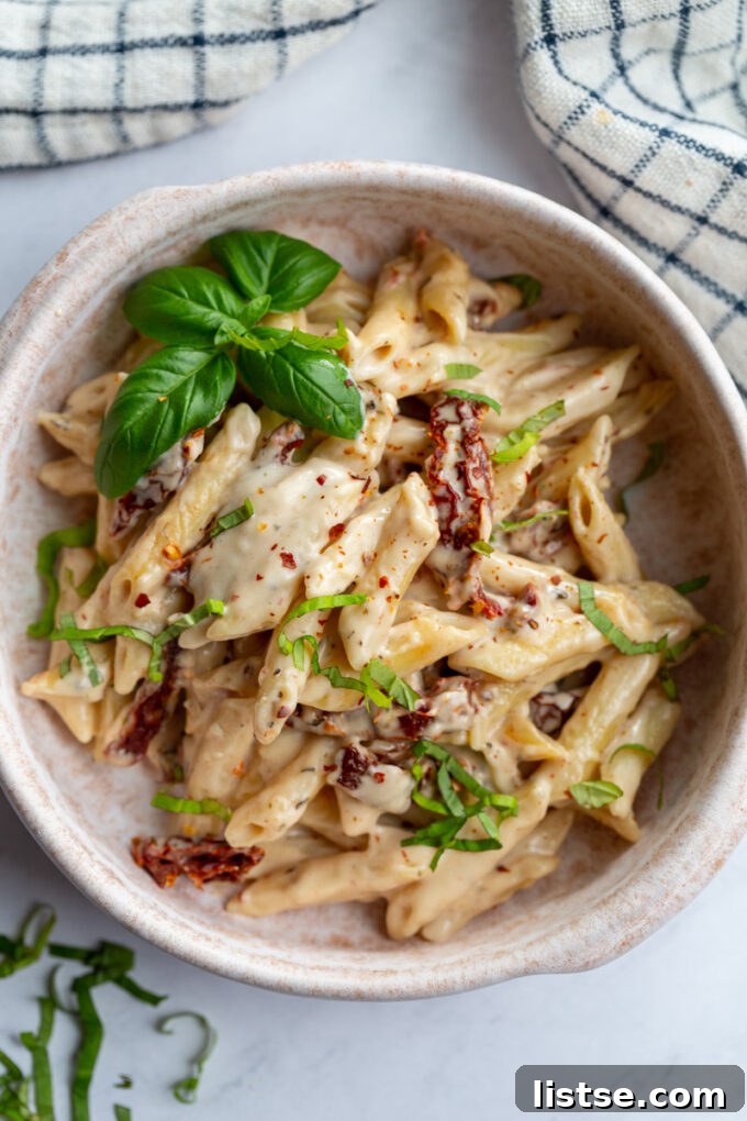 Creamy chickpea pasta served in a stylish bowl, garnished with herbs.