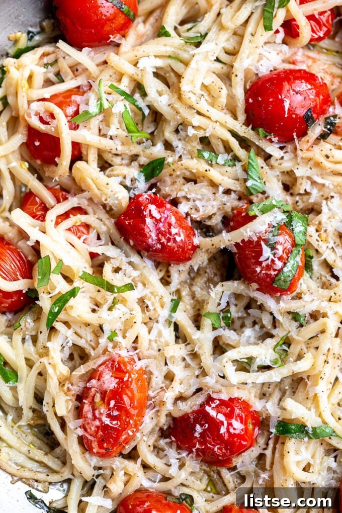 Hearts of palm pasta topped with parmesan cheese and bursting cherry tomatoes, garnished with fresh basil.