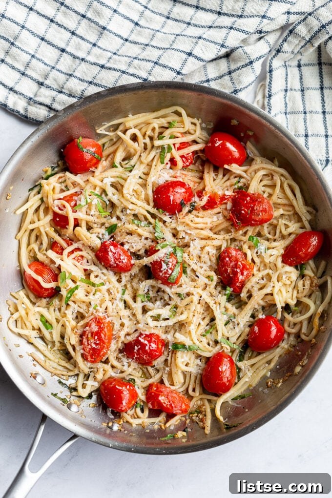 Hearts of palm pasta noodles and cherry tomatoes cooked together in a large skillet, glistening with olive oil.
