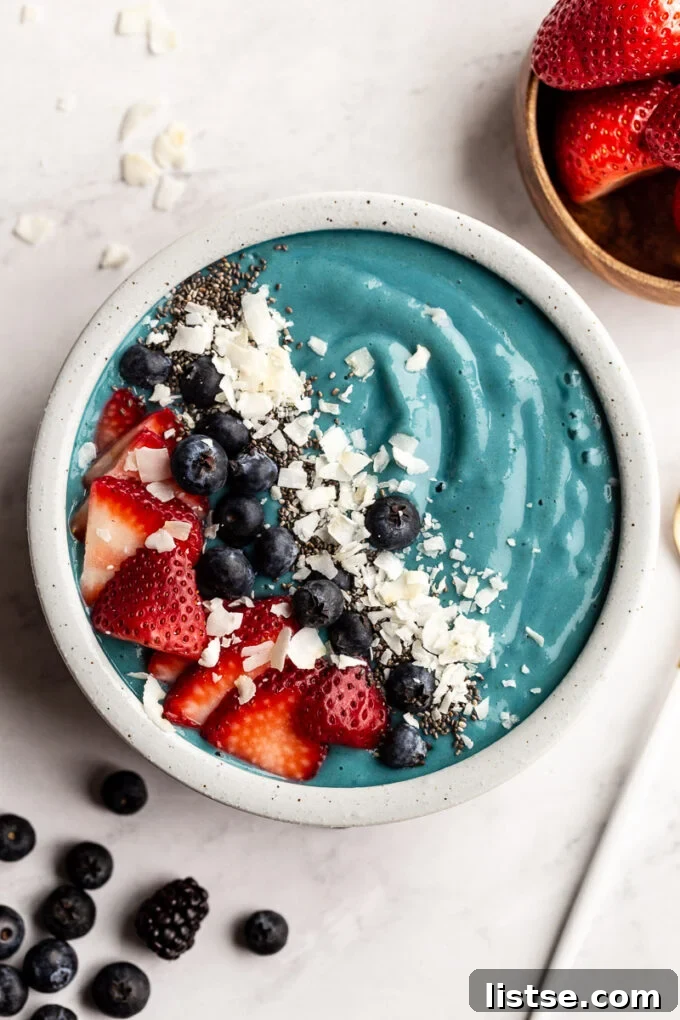Vibrant Blue Spirulina Smoothie 2 A beautifully crafted Blue Spirulina Smoothie bowl adorned with fresh berries, sliced banana, and a sprinkle of shredded coconut.