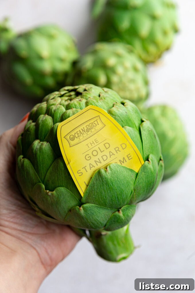 Fresh, whole artichoke with an Ocean Mist Farms tag, emphasizing quality produce