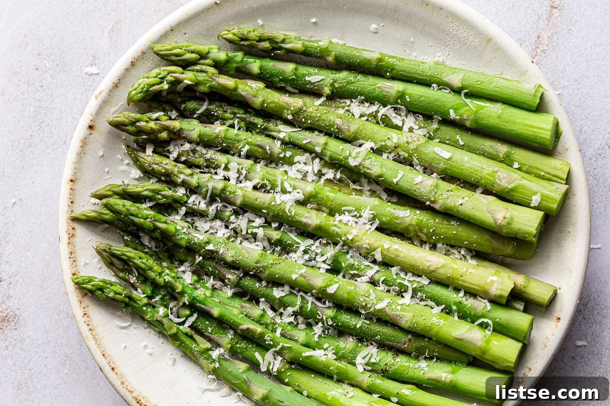 Speedy Skillet Asparagus 2 Cooked asparagus on a plate with a sprinkle of parmesan cheese.
