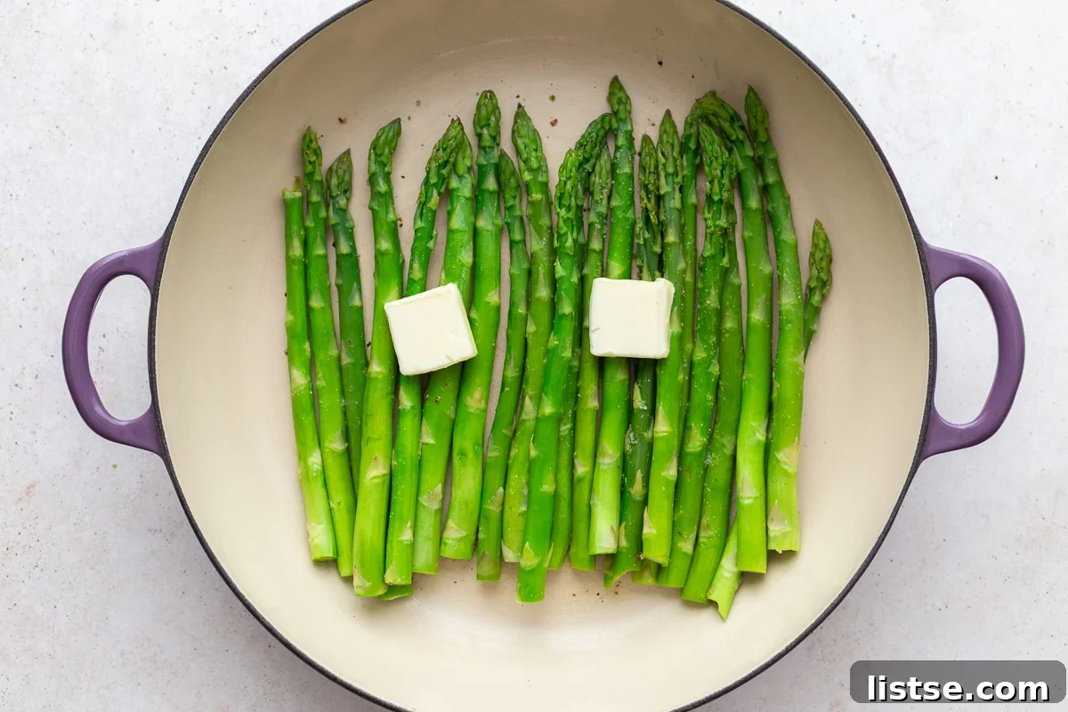 Speedy Skillet Asparagus 8 streamed asparagus in a large skillet with pads of butter on top