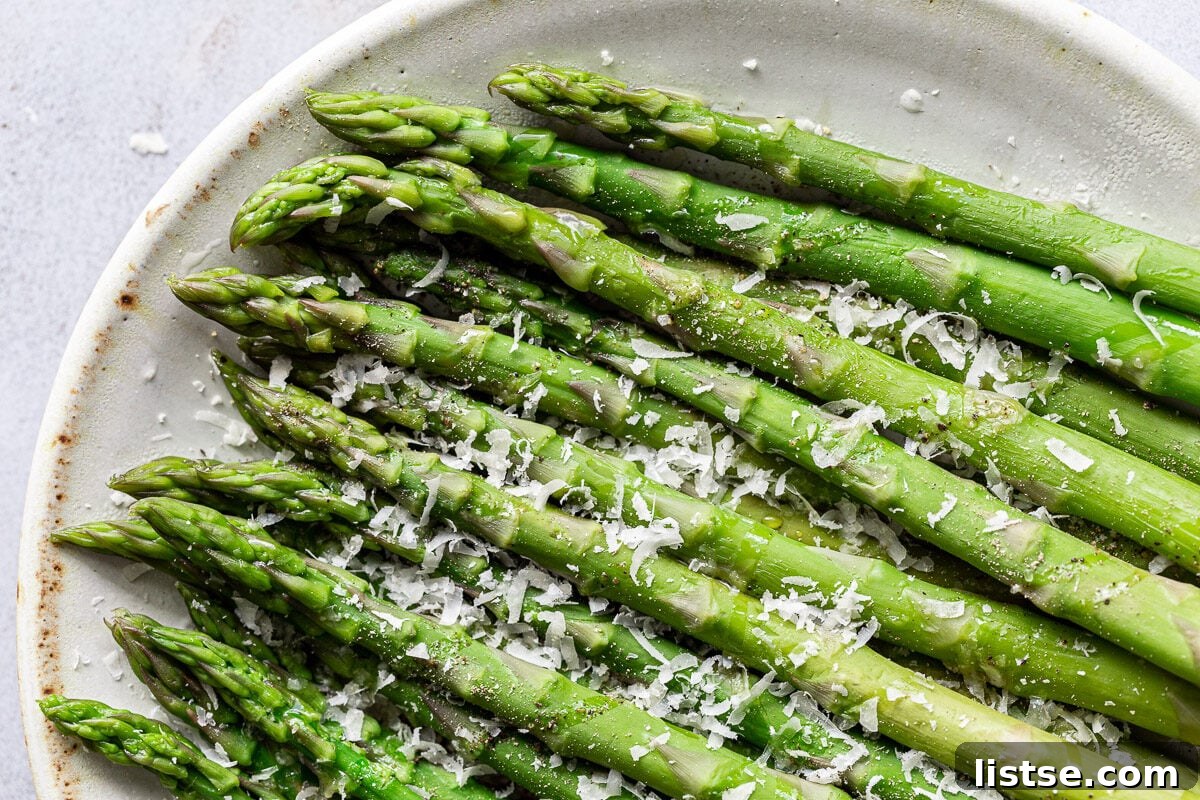 Speedy Skillet Asparagus 10 Parmesan asparagus on a white plate.