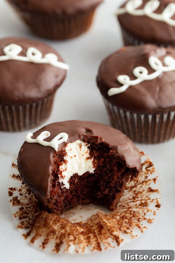 Delightful vegan Hostess-style chocolate cupcake with creamy white filling and shiny chocolate ganache