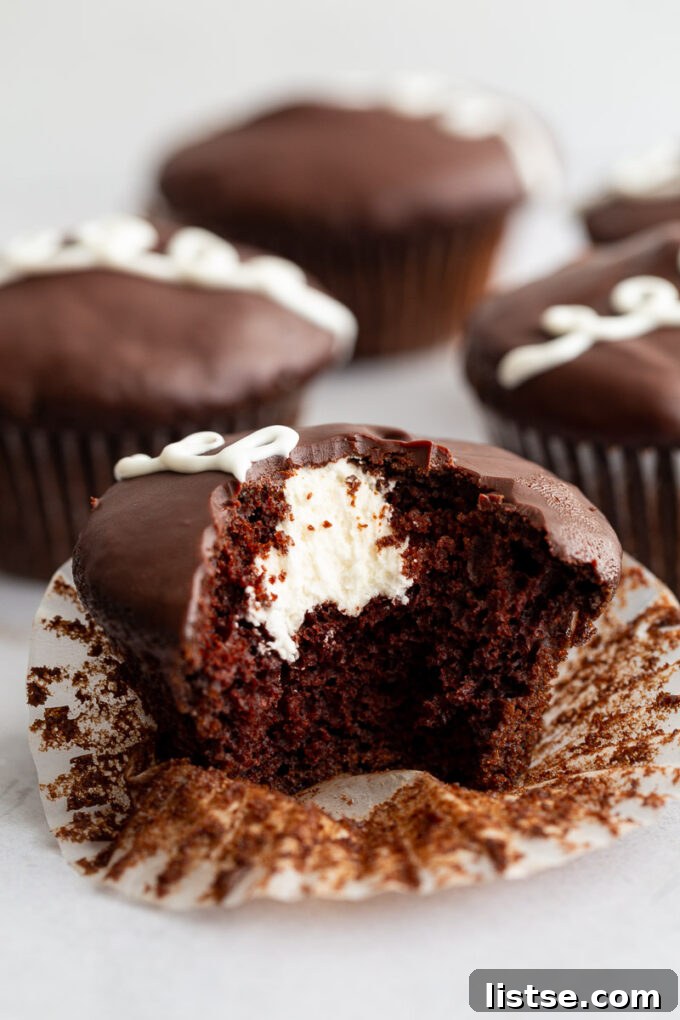 Another close-up of a vegan chocolate cupcake with cream filling and ganache, showing the texture after a bite