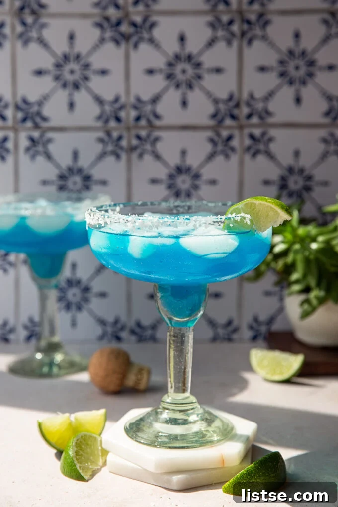 Ocean Breeze Margarita 3 A blue margarita served in a beautifully salted rim glass, ready to be enjoyed.