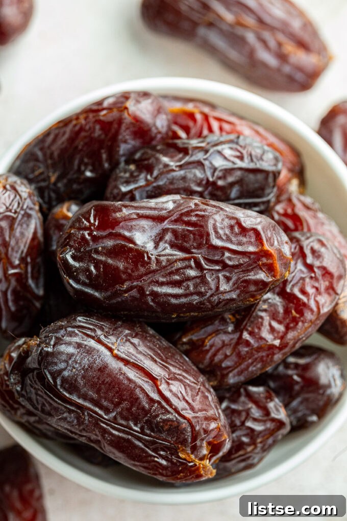A beautiful wooden bowl filled with luscious Medjool dates, ready for consumption