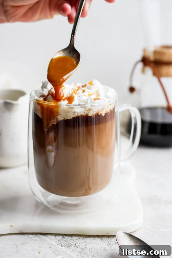 Velvet Caramel Dream 3 A spoon drizzling homemade caramel sauce over the frothy top of a freshly made latte.