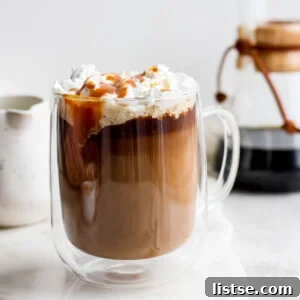 Caramel latte topped with whipped cream and caramel drizzle.