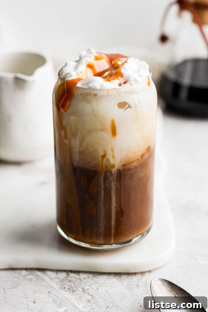 Coffee drink topped with whipped cream and caramel drizzle.