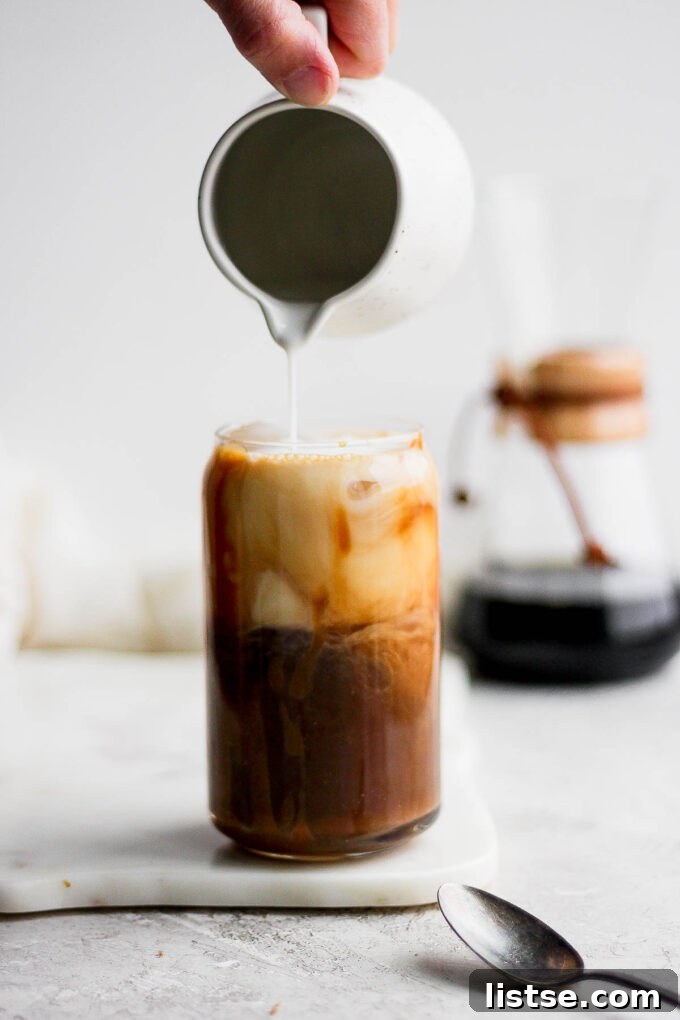 Pouring milk into a coffee.