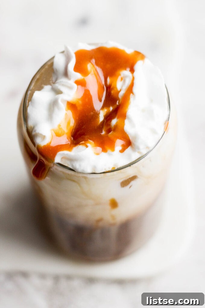 Whipped cream and caramel drizzle over coffee drink.