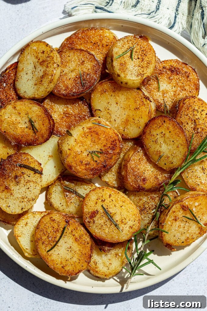 Crispy golden potato coins garnished with fresh rosemary