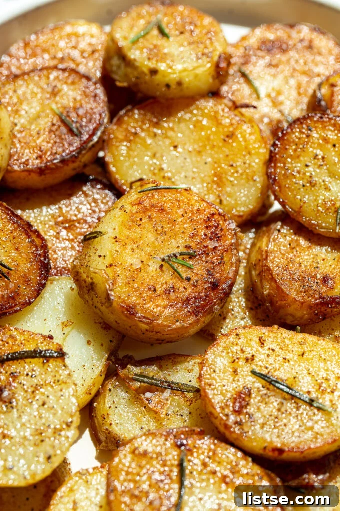 Close-up shot of crispy pan-fried potatoes seasoned with fresh rosemary