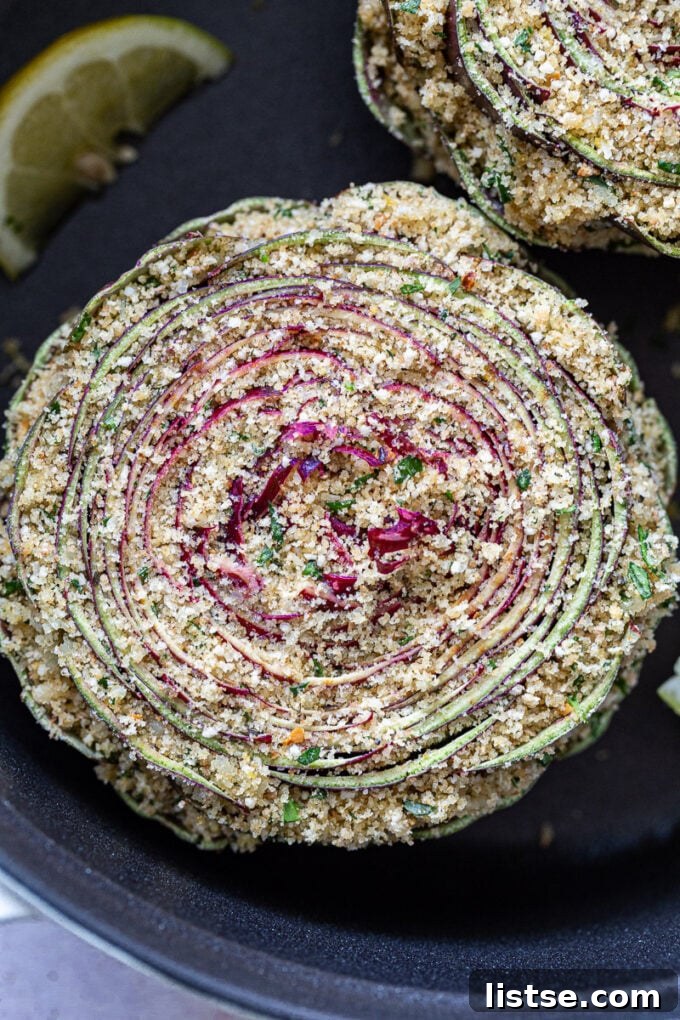 Gourmet Stuffed Purple Artichokes 4 A purple artichoke in a pot, generously stuffed with a bread crumb and cheese mixture, ready for cooking.