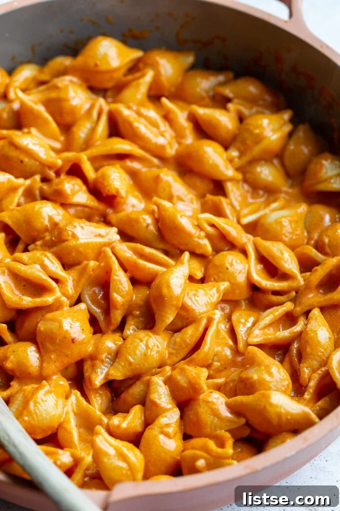 A large skillet filled with creamy Gigi Hadid pasta shells, garnished with fresh basil, ready for serving.