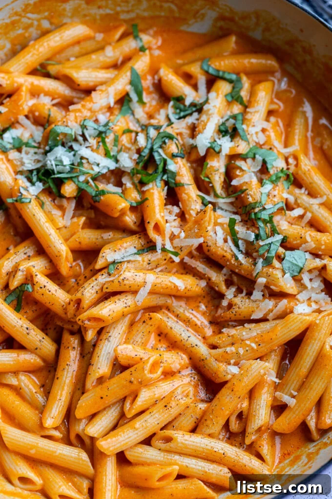 Penne pasta with fresh basil sprinkled over the top, showcasing the texture.