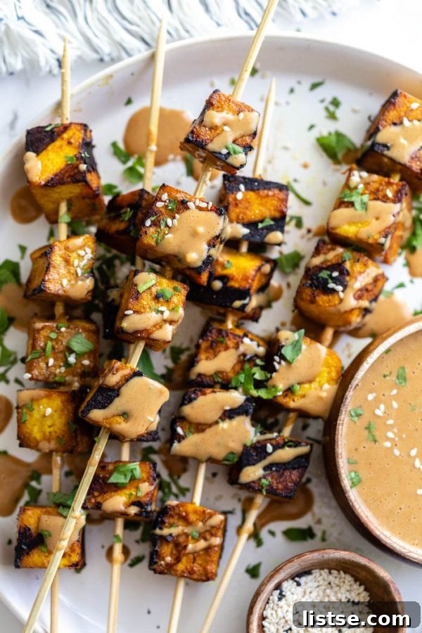 Sizzling Vegetarian Grills 11 Chunks of perfectly grilled tofu on skewers, generously topped with a rich peanut sauce, creating a delectable Tofu Satay.