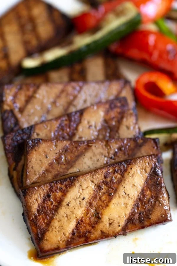 Sizzling Vegetarian Grills 6 Grilled tofu served on a plate with an assortment of colorful grilled vegetables, showcasing a healthy and delicious plant-based meal.