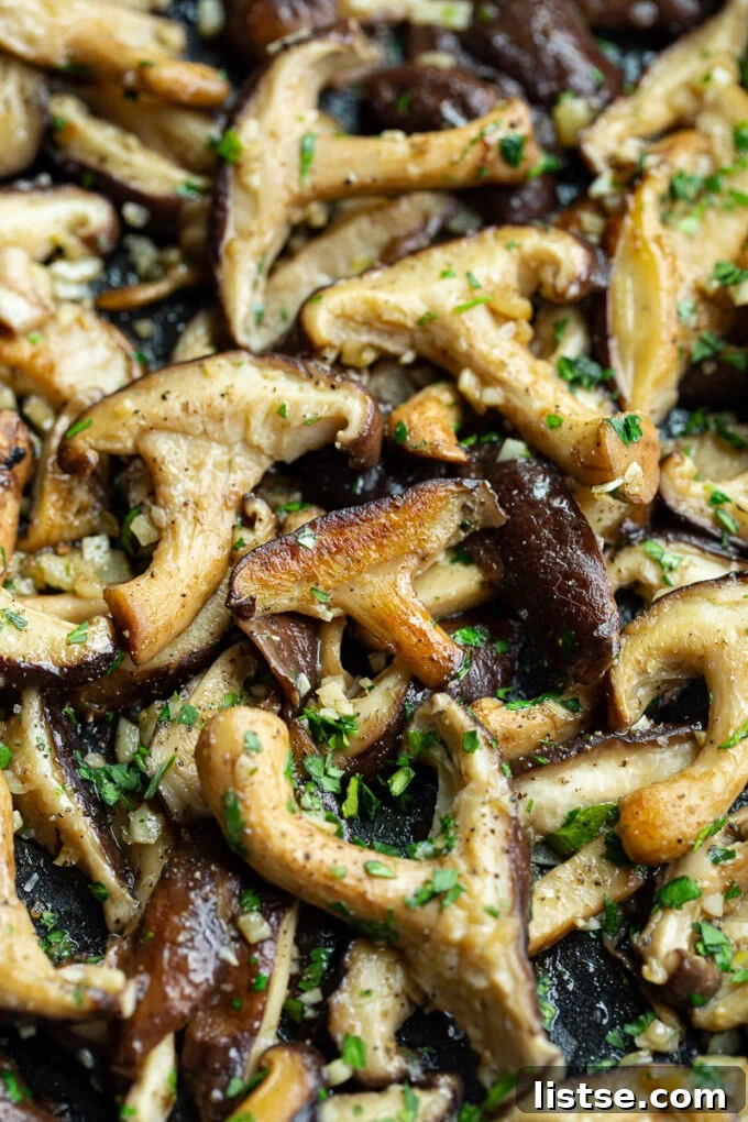Mushrooms that are cooked and garnished with fresh parsley.