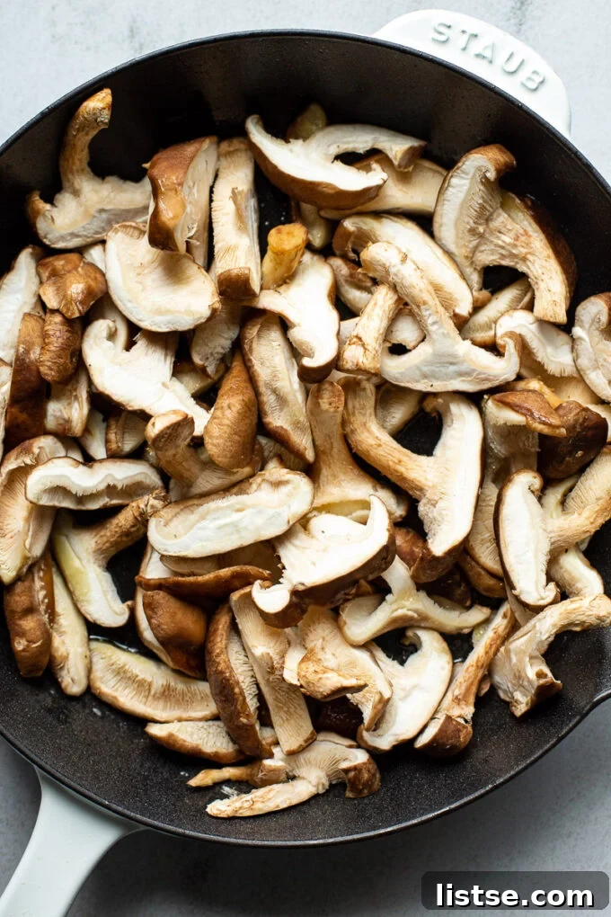 Adding shiitake mushrooms to a pan.