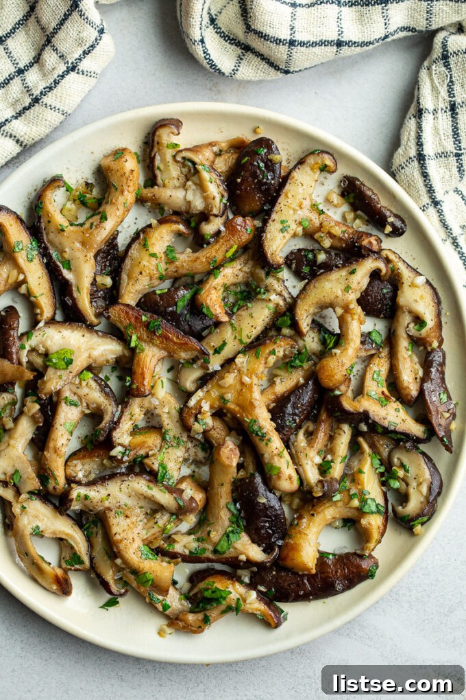 Cooked shiitake mushrooms on a white plate.