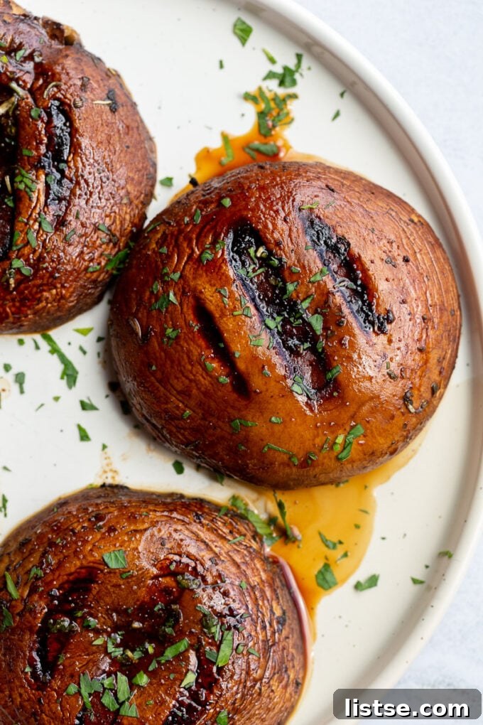 Garnished grilled portobello mushrooms with fresh green parsley, ready to be served.