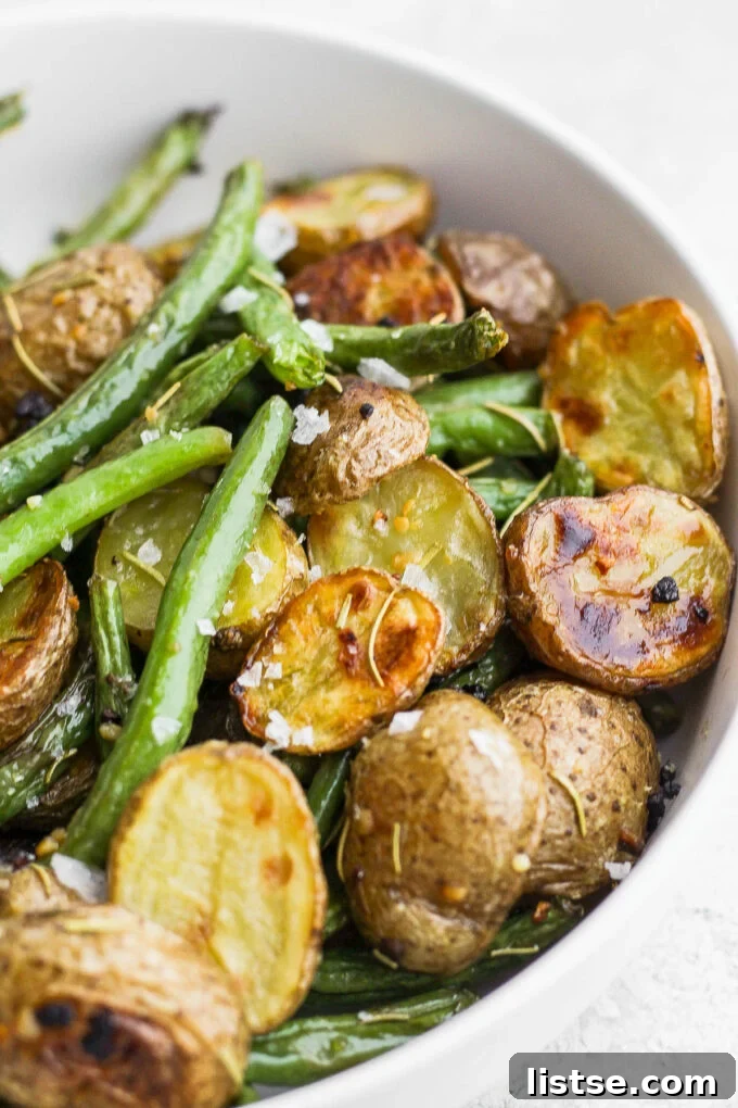 Golden Roasted Potatoes with Tender-Crisp Green Beans 7 Green beans and potatoes in a white bowl, ready to be served.