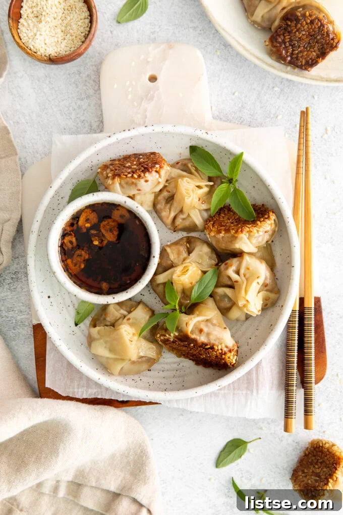 Plant-Powered Parcels 2 Crispy vegan dumplings served on a white plate with a side of dipping sauce, ready to be enjoyed.