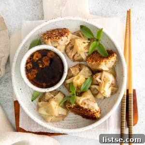 Plant-Powered Parcels 9 Crispy vegan dumplings served on a white plate with a side of dipping sauce.