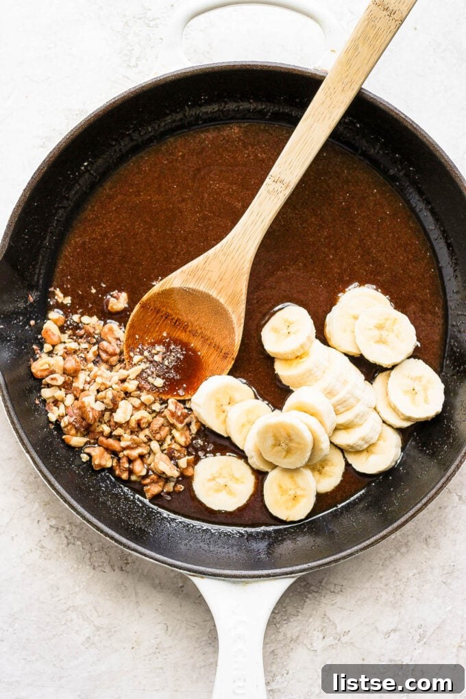 A close-up shot of bananas and sauce simmering in a skillet, creating the bananas foster topping.